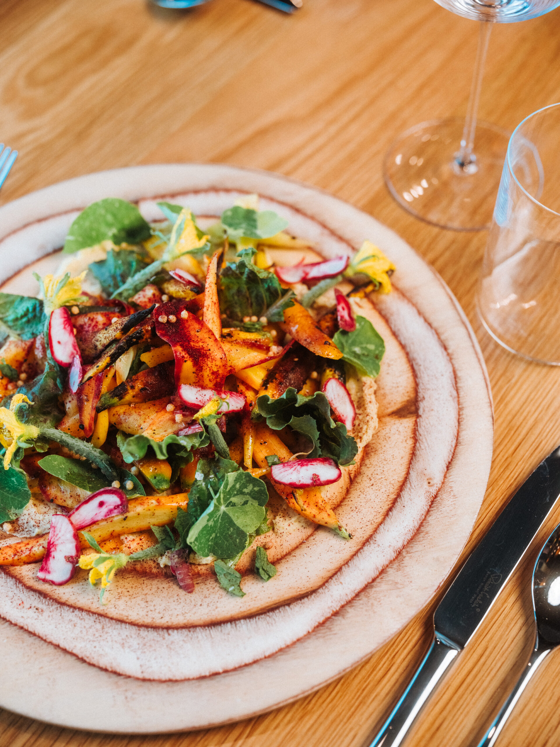 Colorful seasonal dish with vegetables and greens served at Fields Restaurant at Skaneateles Fields Resort & Spa.