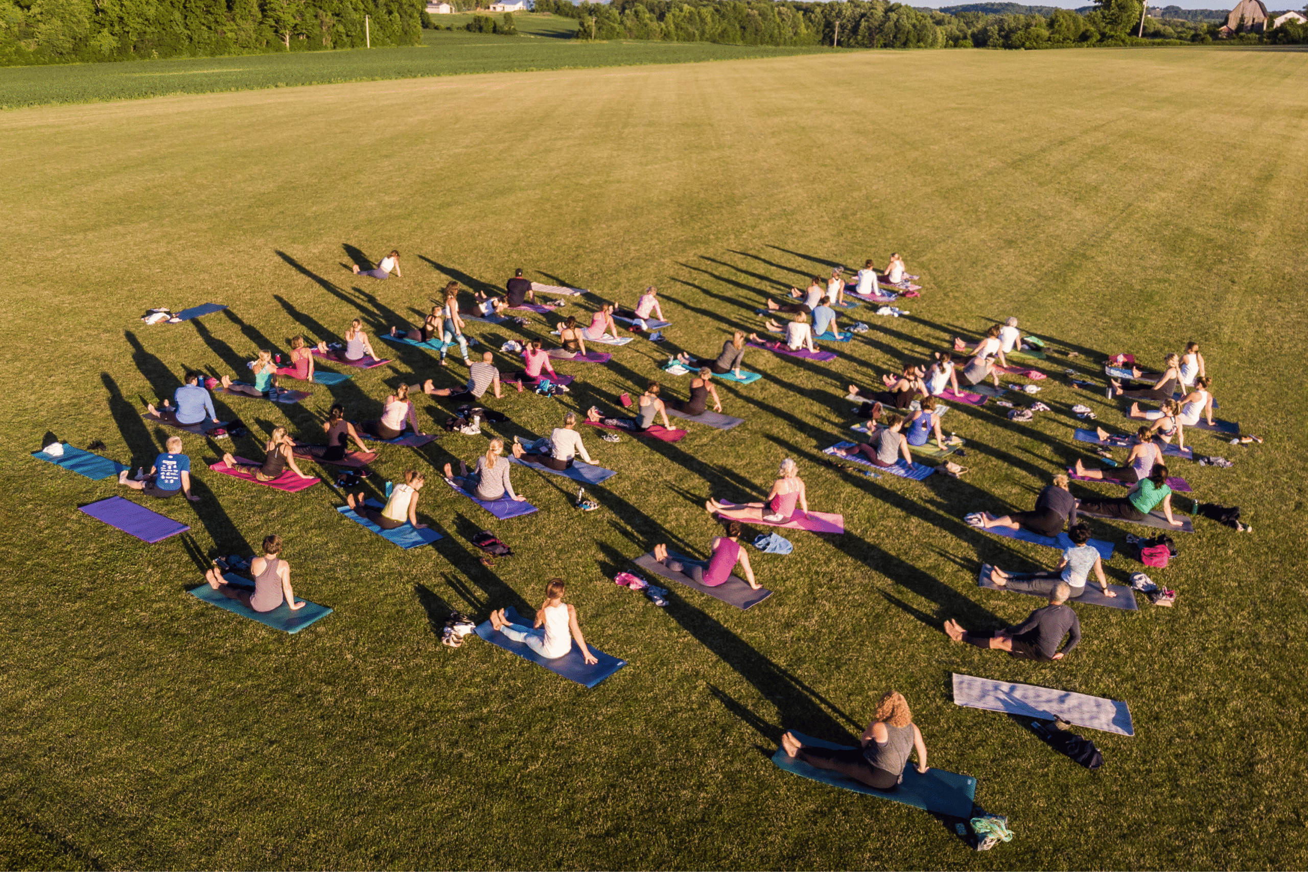 Guests participating in an outdoor Sky Yoga class on the lawn at Skaneateles Fields Resort & Spa.