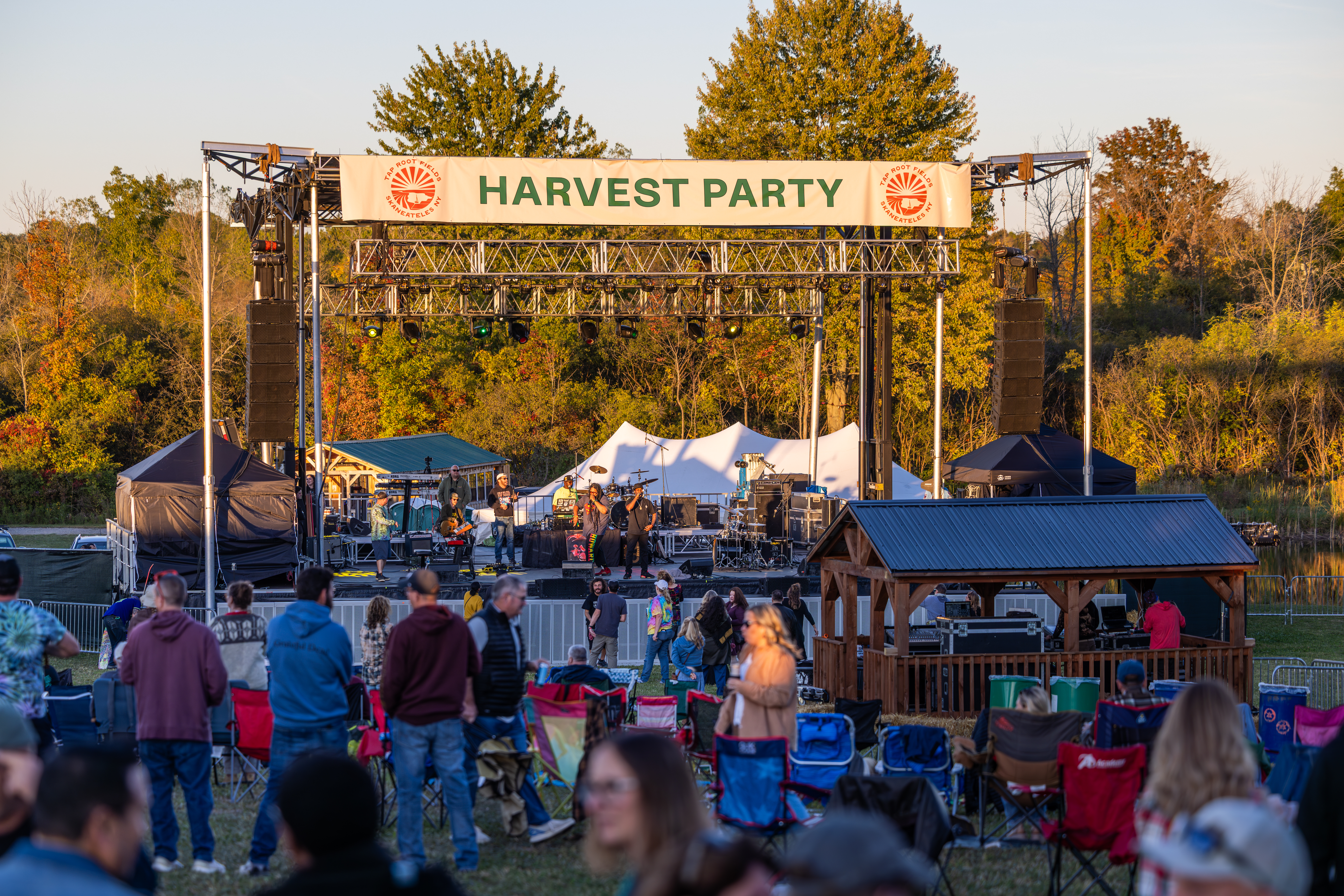 Guests gathered at the annual Harvest Party at Tap Root Fields, enjoying live music in an outdoor setting near Skaneateles Fields.