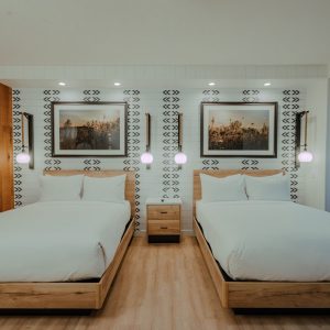 ADA Double Queen guest room with two beds, wood accents, and Finger Lakes-inspired artwork at Skaneateles Fields Resort & Spa.